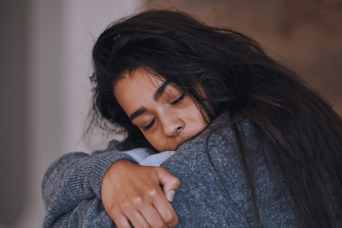 woman with bipolar disorder hugs knees to her chest in depressive episode