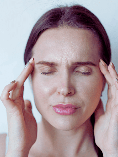 woman with migraine rubs temples