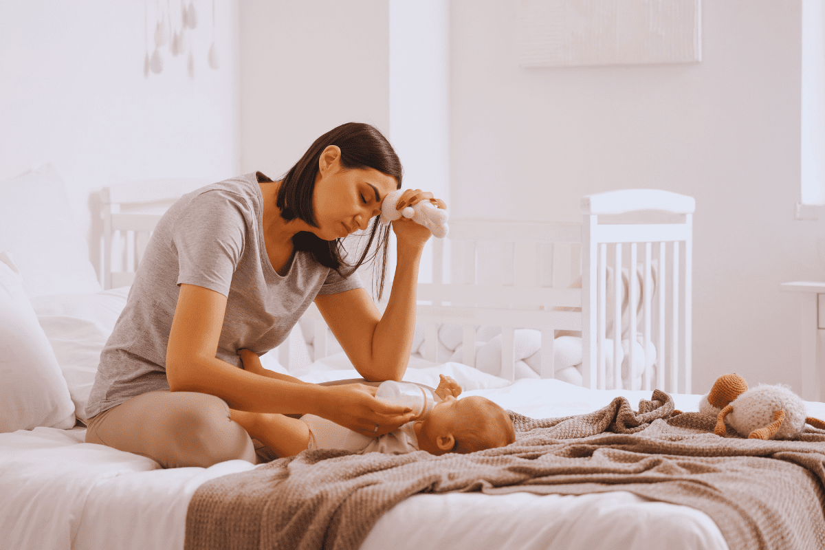 woman in bed with new baby experiencing postpartum depression